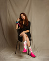 Model styling pink lizard western boots in city fashion